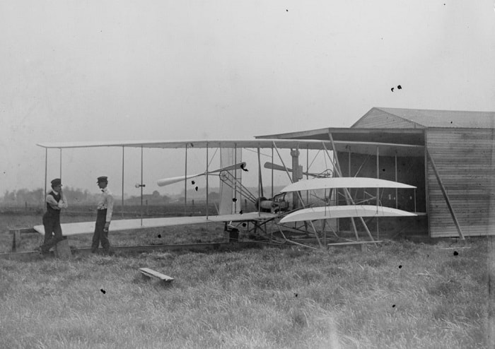 Wilbur, Orville ve Flyer II hangarlarının önünde tartışma içindeler  / Wright Kardeşler