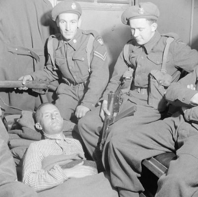 29 Mayıs 1945'te Almanya'nın Flensburg kentinde İngiliz subaylar tarafından William Joyce'un tutuklanması. Tutuklama sırasında vurulduğu için sedyede / Radyo