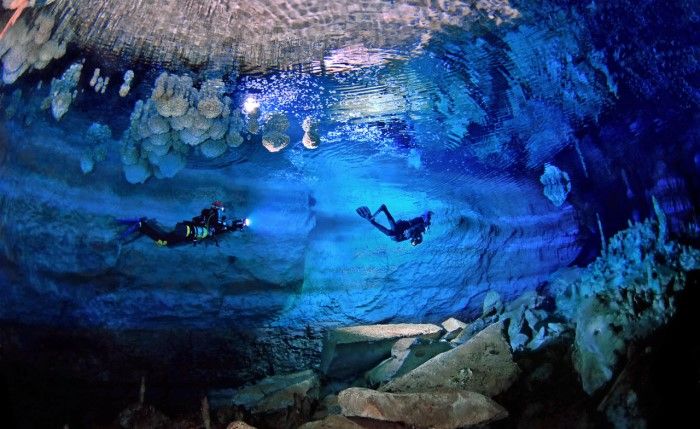 Dalgıçlar deniz seviyesinde bir mağarada yüzüyor