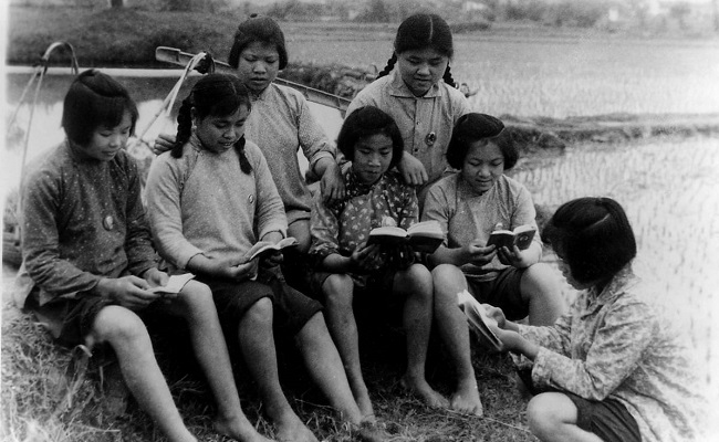 Köylüler pirinç ekiminde verdikleri mola sırasında Başkan Mao'nun Kültür Devrimi'nin 'İncil'i olan Küçük Kırmızı Kitap'ın içimdeki sözleri inceliyorlar, 1970, Guangxi
