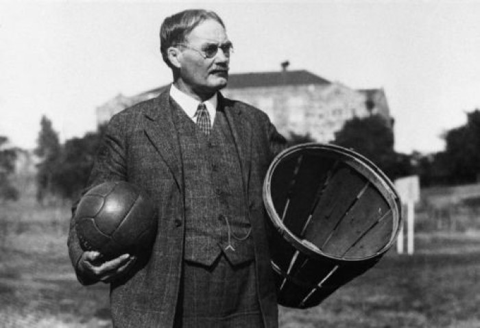 Elinde bir futbol topu ve şeftali sepeti ile basketbolu icat eden beden eğitimi öğretmeni James Naismith.