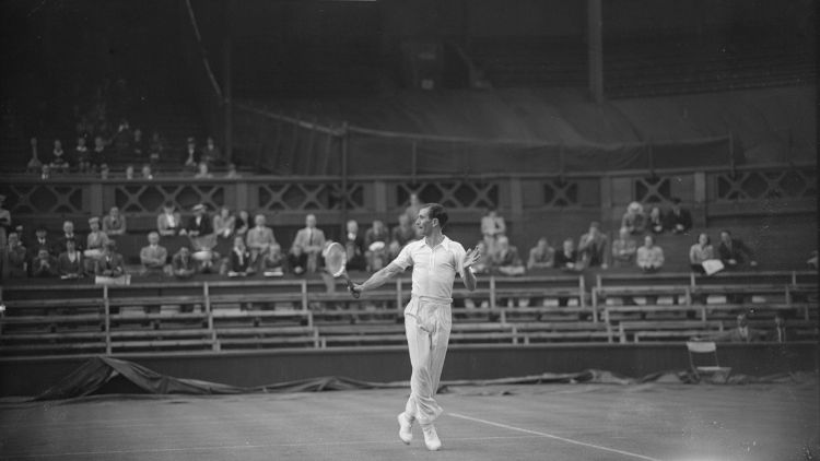 İngiliz tenisçi D. W. Butler, 24 Haziran 1946'da, İkinci Dünya Savaşı'nın sona ermesinin ardından ilk Wimbledon Çim Tenisi Şampiyonası sırasında Merkez Kort'ta D. Scharenguivel'e karşı.