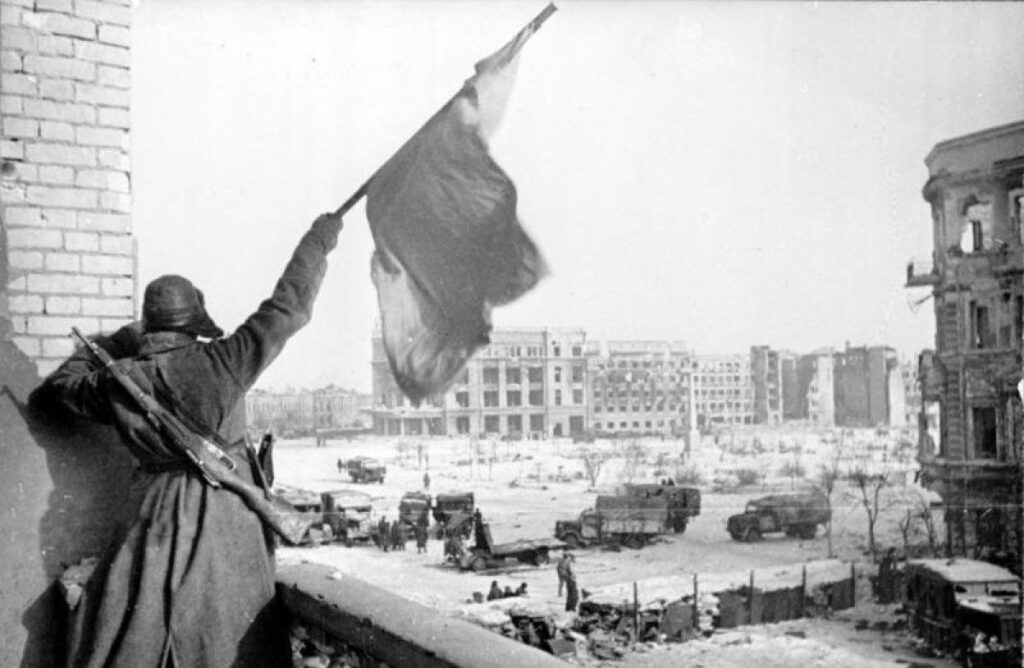 Bir Sovyet askeri Stalingrad meydanından kızıl bayrağı sallarken.