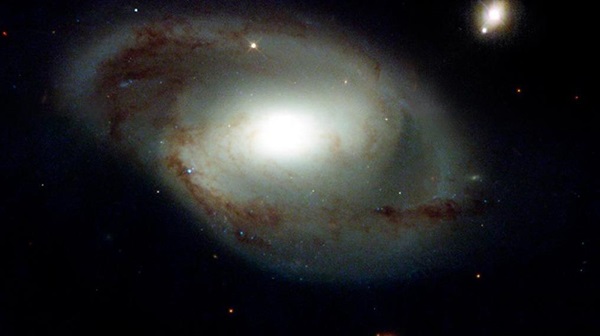 NGC 4319 galaksisi ve Markarian 205 kuasarı (sağ üstte). NGC 4319, Dünya'dan 80 milyon ışık yılı uzaklıkta ve kuasar ise 1 milyar ışık yılı uzaklıkta.
