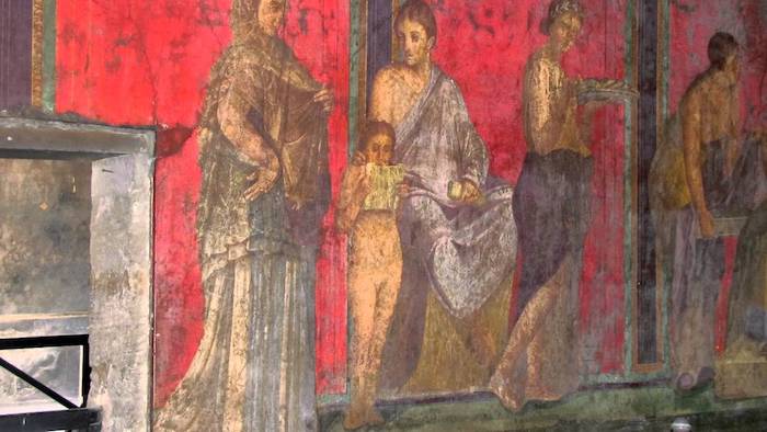 Pompeii antik kentindeki antik bir Roma villasının fresklerinde okuyan bir kız çocuğu, Villa dei Misteri'nin (Gizemler Villası)