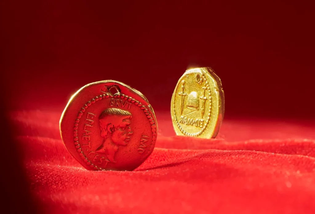 Brutus tarafından Jül Sezar'ın öldürülmesinden sonra basılan bir Roma altın sikkesinin kopyası, iki hançer arasındaki şapka özgürlüğü temsil ediyor. Kaynak: Smithsonian
