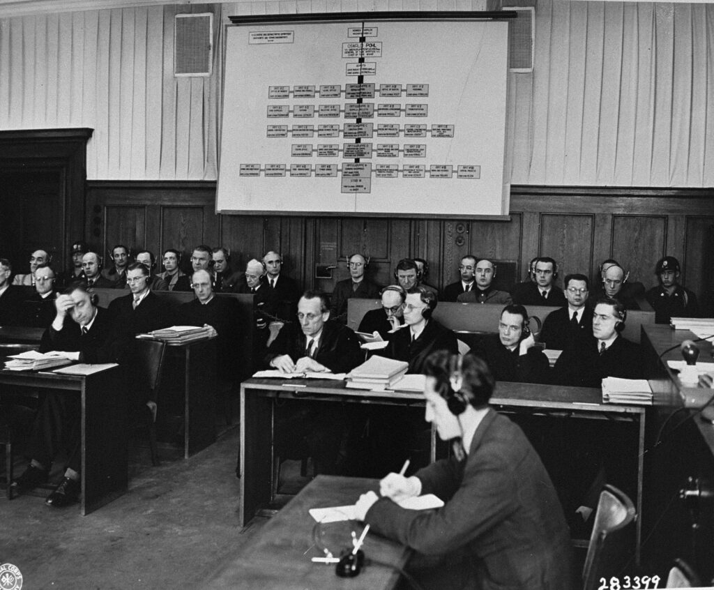 Sanıklar (arkada) ve avukatları (önde) Nürnberg'deki dördüncü duruşma olan Pohl/WVHA davasının duruşmalarını takip ediyor.
