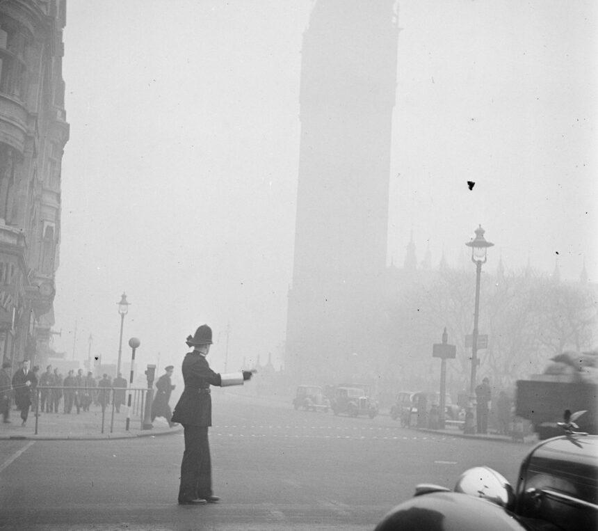 Een agent regelt het verkeer in de mist Op de achtergrond is Big Ben te zien Bestanddeelnr 254 1948