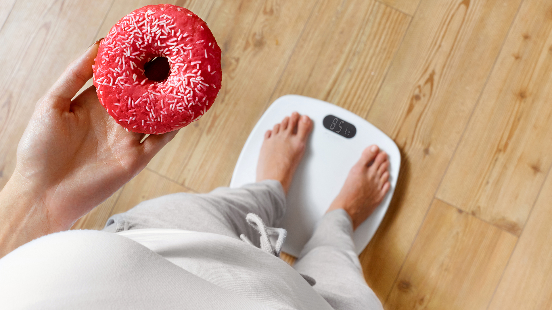 Diyet. Tartıda Vücut Ağırlığını Ölçen Kadın Donut Tutuyor. Tatlılar Sağlıksız Abur Cuburlardır.