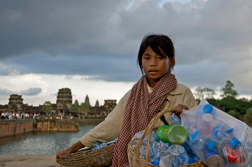 Angkor Wat, Kamboçya, Siem Reap'i ziyaret eden turistlerin bıraktığı plastik şişeleri toplayan genç bir khmer kızı.  
