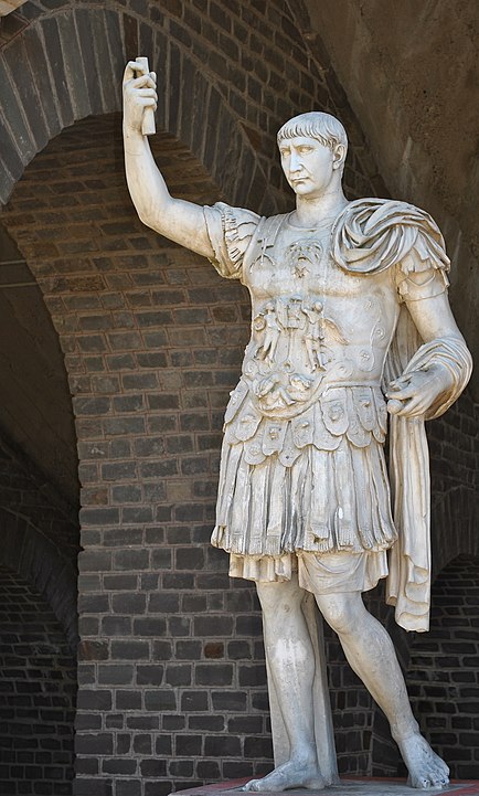 Xanten Arkeoloji Parkı'ndaki Colonia Ulpia Traiana Amfitiyatrosu önünde askeri kıyafetler içinde poz veren Trajan heykeli
