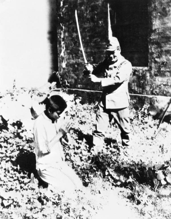 Bir Japon askeri genç bir Çinli çocuğun kafasını alenen kesmeye hazırlanıyor.
